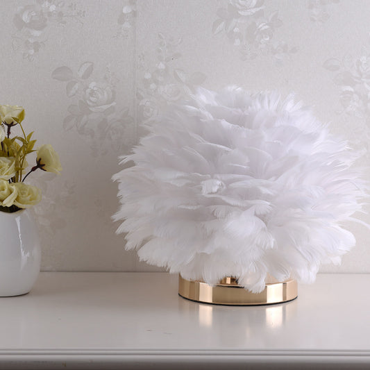 Plume Feather Table Lamp — white feather table lamp glowing warmly on a bedside table