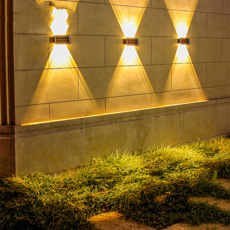Solstice Solar Wall Light — solar up-down wall lights casting warm beams on an exterior wall at night