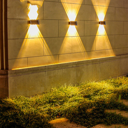 Solstice Solar Wall Light — solar up-down wall lights casting warm beams on an exterior wall at night